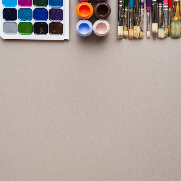 Photo gratuite ensemble de brosses à soies près de peintures