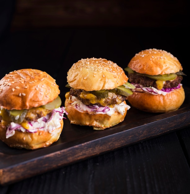 Ensemble de délicieux hamburgers sur une planche de bois