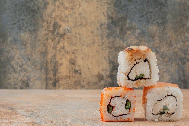 Ensemble de délicieux rouleaux de sushi sur une surface en marbre