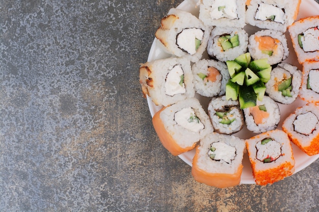 Ensemble de délicieux sushis différents sur plaque en bois