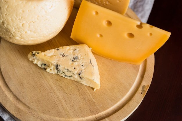 Photo gratuite ensemble de fromage frais sur une planche de bois