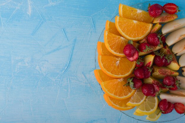 Ensemble de fruits en tranches dans un plateau en verre isolé sur espace bleu