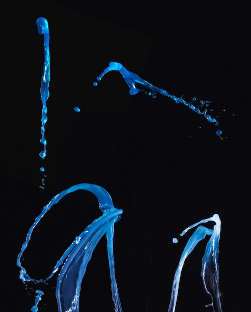 Photo gratuite ensemble de liquide bleu éclaboussant sur fond sombre