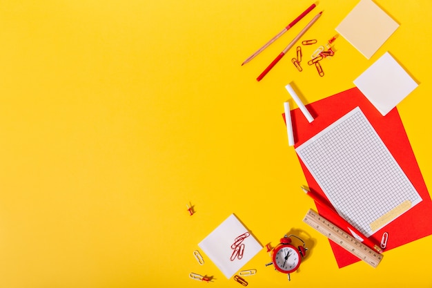 Ensemble lumineux de papeterie scolaire composé de rouge et de papier, trombones, crayons de couleur, crayons et règle en bois