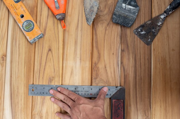 Ensemble d'outils manuels, situé sur un plancher en bois.