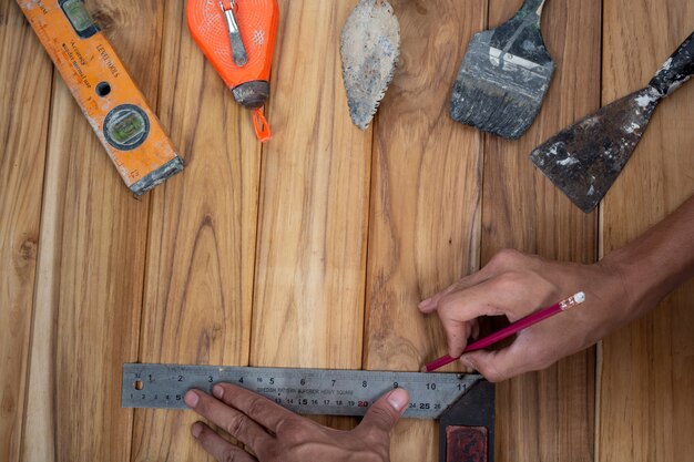 Ensemble d'outils manuels, situé sur un plancher en bois.