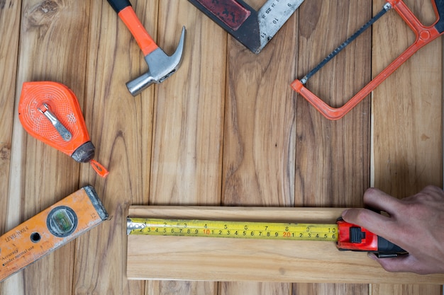 Ensemble d'outils manuels, situé sur un plancher en bois.