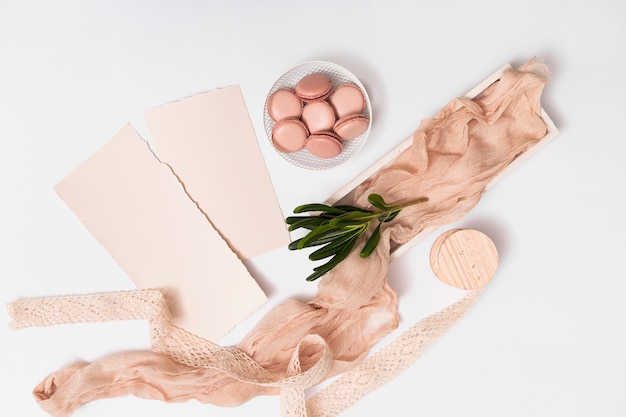 Ensemble de papier et macarons sur une assiette près de textile