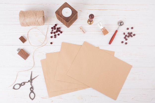 Ensemble de papiers près de ciseaux, torsades, bougie et clé USB