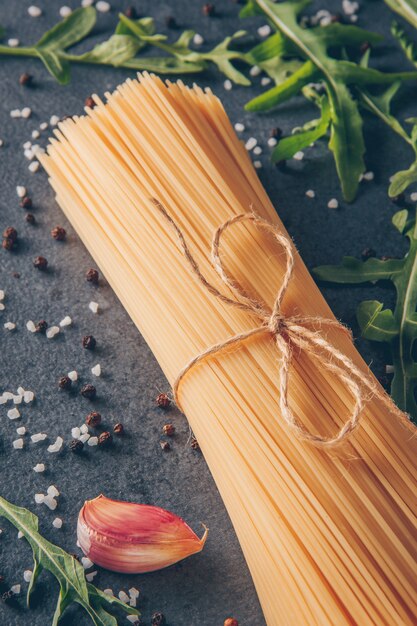 Ensemble de pâtes vertes et ail et spaghetti sur un fond texturé gris. vue grand angle.