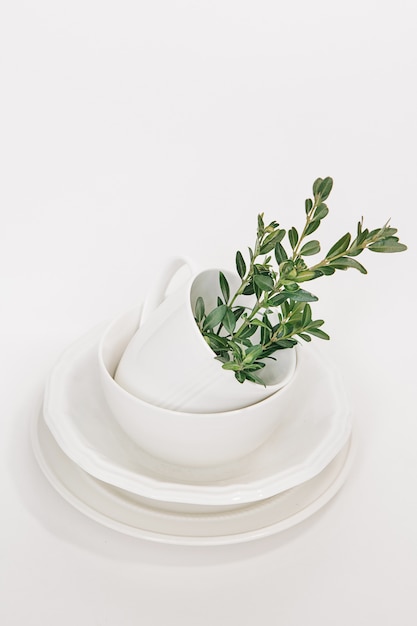 ensemble de plats blancs de trois assiettes et une coupe décorée d&#39;une branche d&#39;eucalyptus