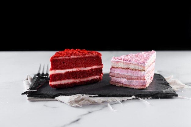 Ensemble de portions de gâteau velours et gâteau aux fraises sur marbre