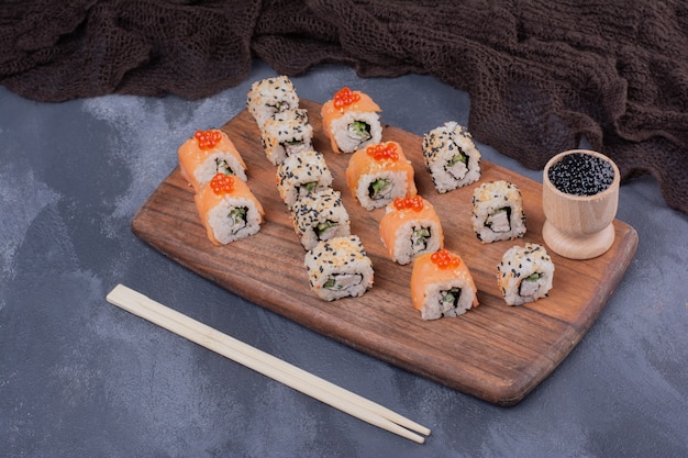 Ensemble de sushi. Philadelphie et l'Alaska roule sur une plaque en bois avec des baguettes.