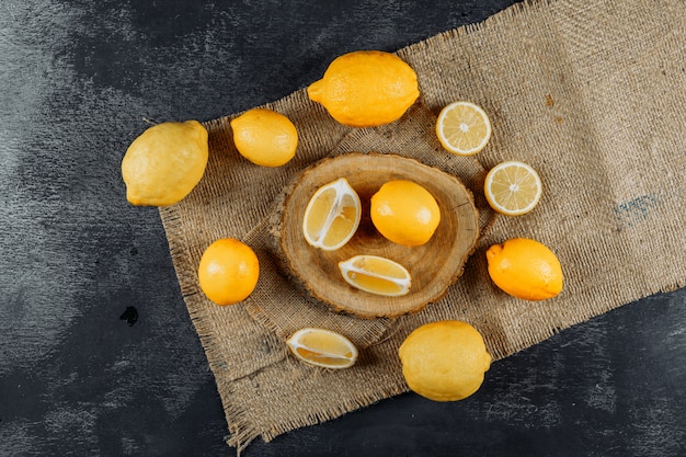 Ensemble de tranches et de citrons sur un tissu et un fond sombre. vue de dessus.