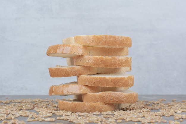 Ensemble de tranches de pain grillé avec des grains d'avoine sur une surface en marbre