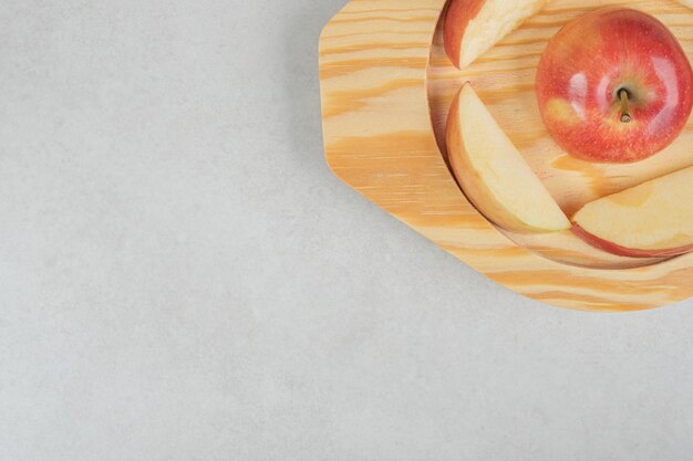 Ensemble et tranches de pomme rouge sur plaque en bois
