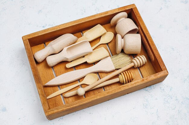 Ensemble d'ustensiles de cuisine en bois sur une surface en béton