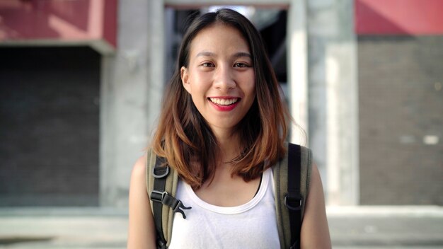 Enthousiaste belle femme asiatique jeune routard se sentir heureux, souriant à la caméra