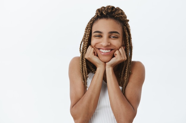 Enthousiaste belle fille afro-américaine souriante adorable et rêveuse