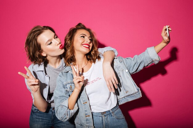 Enthousiaste deux femmes font selfie par téléphone