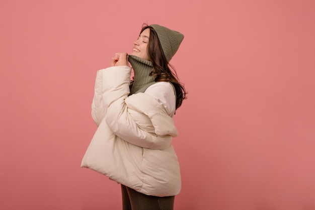 Enthousiaste jeune fille européenne aux cheveux noirs et aux yeux fermés en studio de vêtements d'hiver Les émotions des gens concept de style de vie et de mode