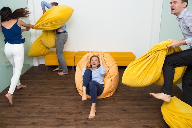 Enthousiaste jeunes gens qui se battent oreillers dans la chambre