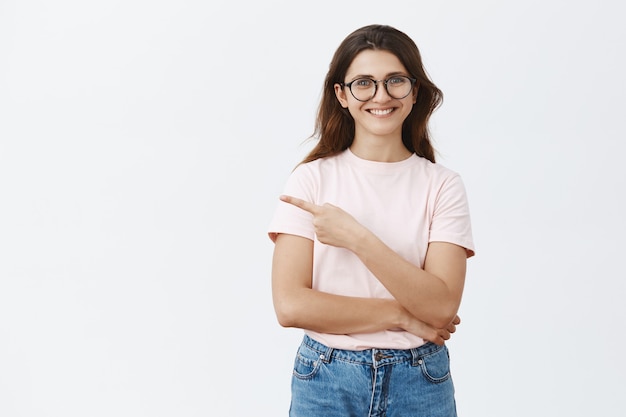 Enthousiaste jolie jeune brune avec des lunettes posant