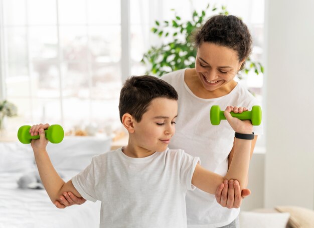 Entraînement d'enfant de tir moyen avec des haltères