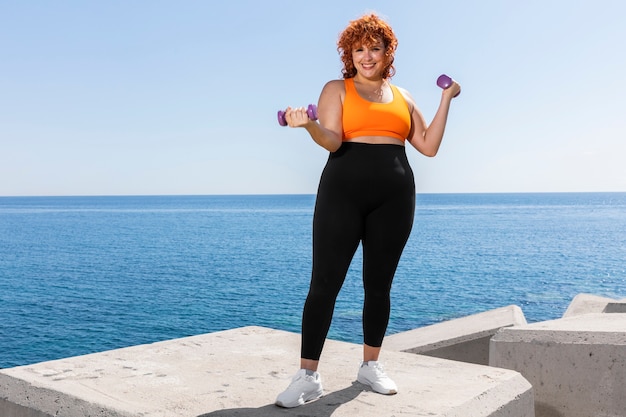 Entraînement de femme plein coup avec des haltères