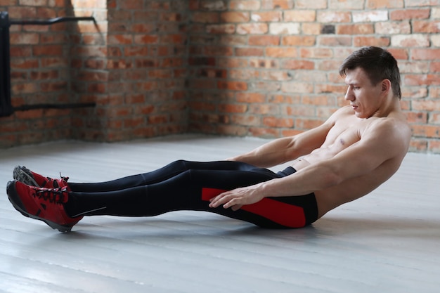 Photo gratuite entraînement de fitness homme. homme torse nu faisant des étirements à la maison