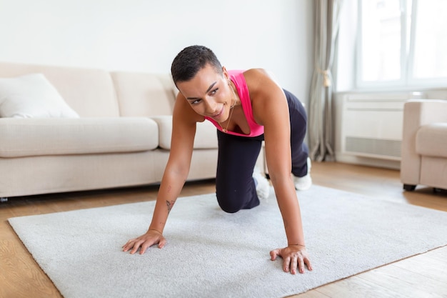 Entraînement de routine Fit une femme noire athlétique active faisant de l'exercice d'alpinistes sur un tapis de yoga une femme sportive forte dans les vêtements de sport entraînant les muscles abdominaux dans un studio de fitness ou à la maison