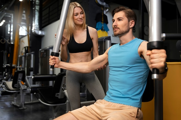 Entraîneur aidant le débutant au gymnase