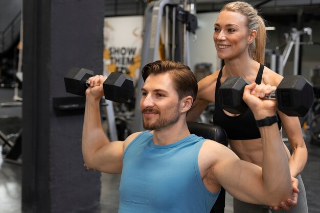 Entraîneur aidant le débutant au gymnase