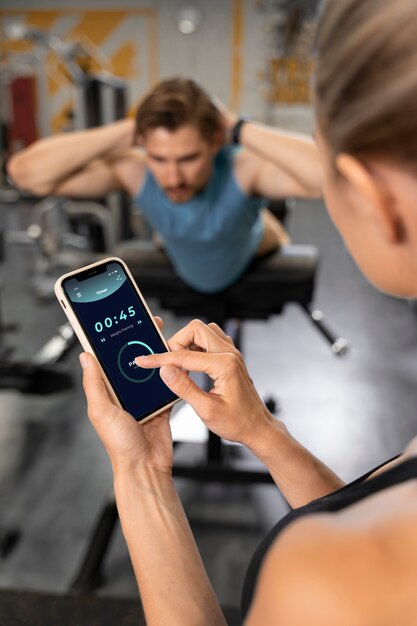 Entraîneur aidant le débutant au gymnase