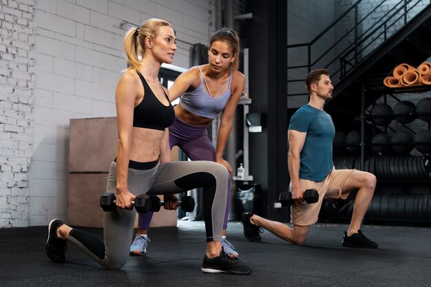 Entraîneur aidant le débutant au gymnase