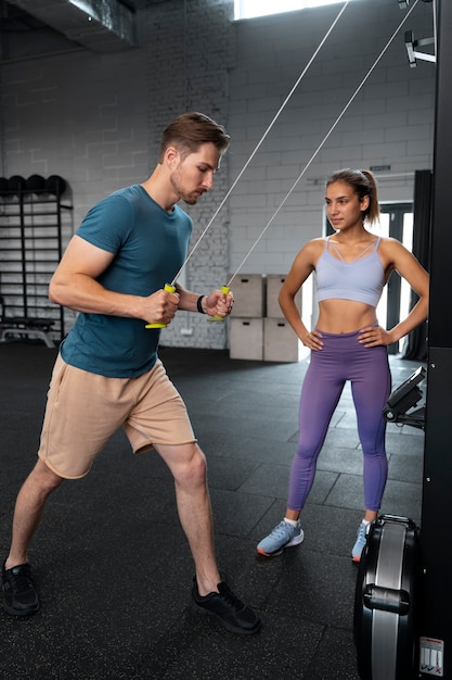 Entraîneur aidant le débutant au gymnase