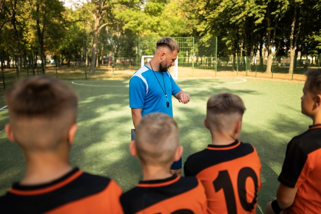 Photo gratuite entraîneur de football enseignant à ses élèves