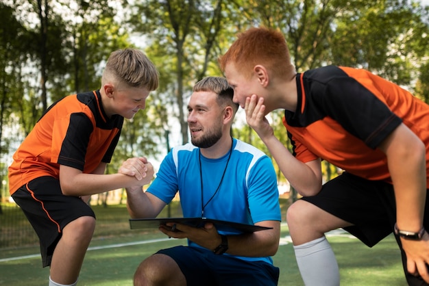 Photo gratuite entraîneur de football enseignant à ses élèves