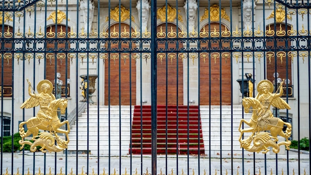 Photo gratuite entrée d'un ancien manoir de luxe à bucarest roumanie détails dorés sur la façade et la clôture