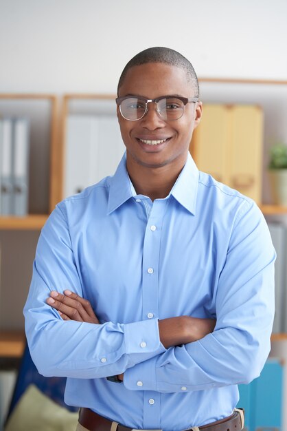 Entrepreneur confiant regardant la caméra avec les bras croisés en souriant