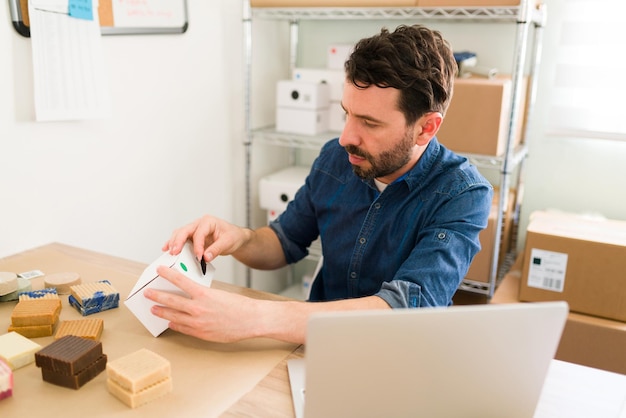 Entrepreneur occupé à préparer de nombreuses commandes de clients dans son magasin de bureau. Propriétaire d'entreprise prospère prêt à expédier des produits de beauté biologiques