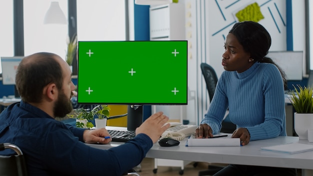 Entrepreneur paralysé expliquant l'évolution financière en pointant sur l'écran vert