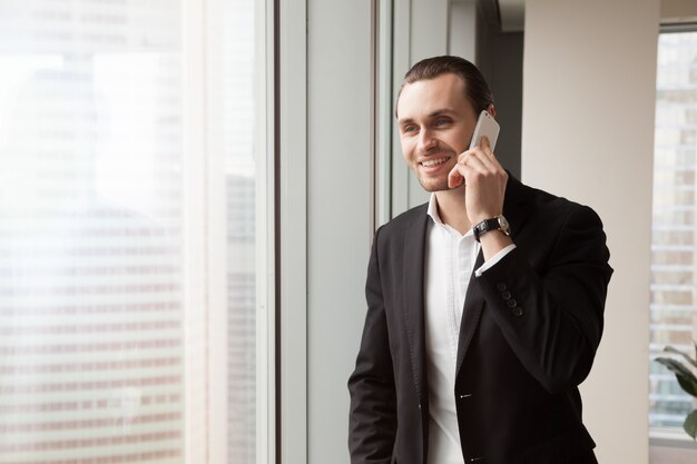 Un entrepreneur souriant répond à l&#39;appel du bureau