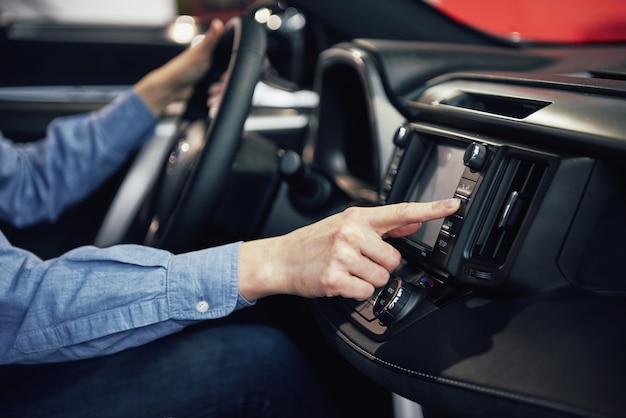 Entreprise automobile, vente de voitures, consommation et concept de personnes - femme heureuse prenant la voiture du concessionnaire dans le salon de l'auto ou le salon