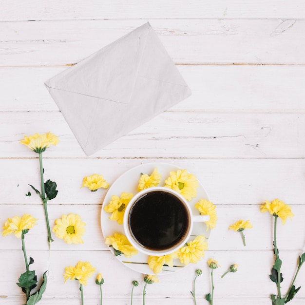 Photo gratuite enveloppe et café en fleurs