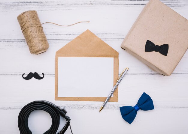 Enveloppe avec papier près de la boîte, fils et bracelet en cuir