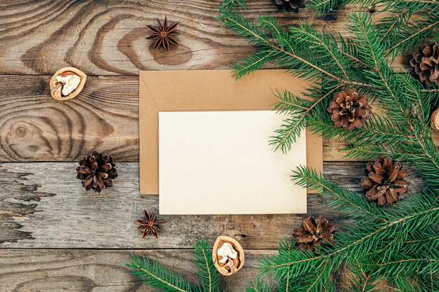 Enveloppe de papier vierge sur un fond en bois avec des branches d'arbres de Noël