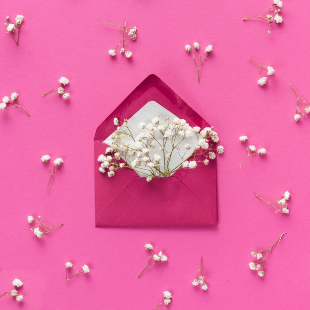 Enveloppe avec petites branches de fleurs sur la table