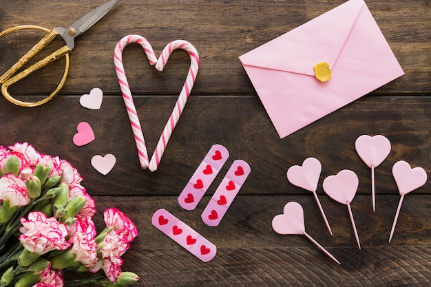 Enveloppe près de bouquet de fleurs, ciseaux et cannes de bonbon