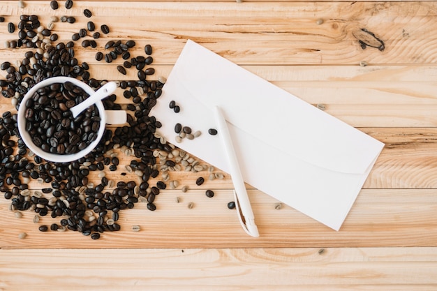 Enveloppe près de la tasse avec des grains de café